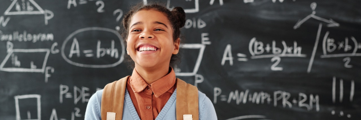 Student, girl smiling in front of chalkboard